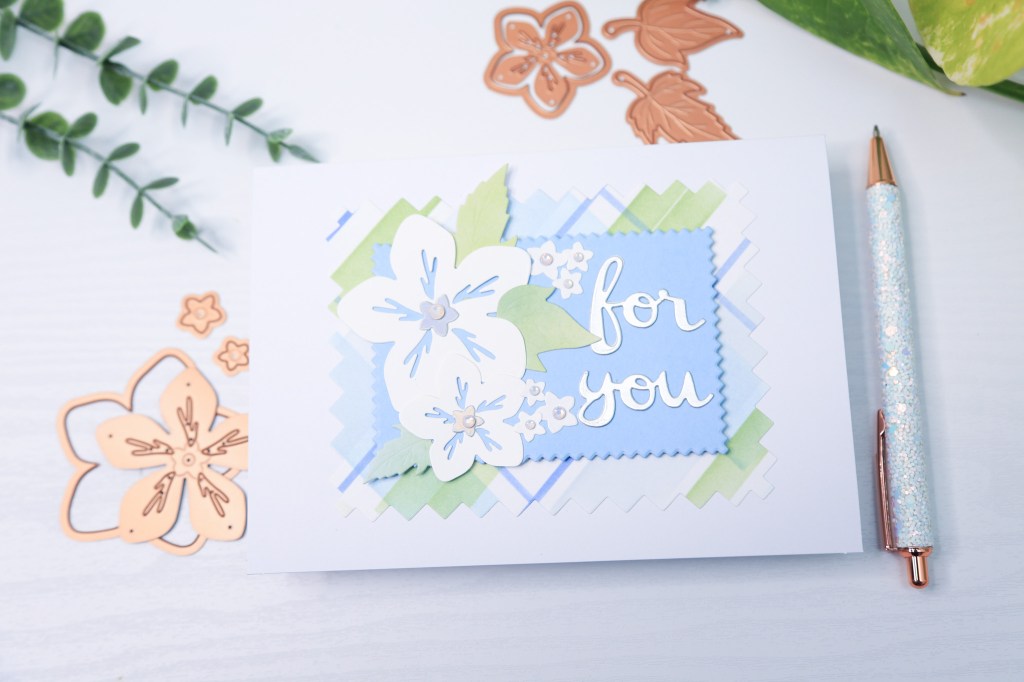 Spellbinders pinking edges dies used to create a greeting card with florals from essential envelope dies by Spellbinders, and Spellbinders' build a plaid stencil set