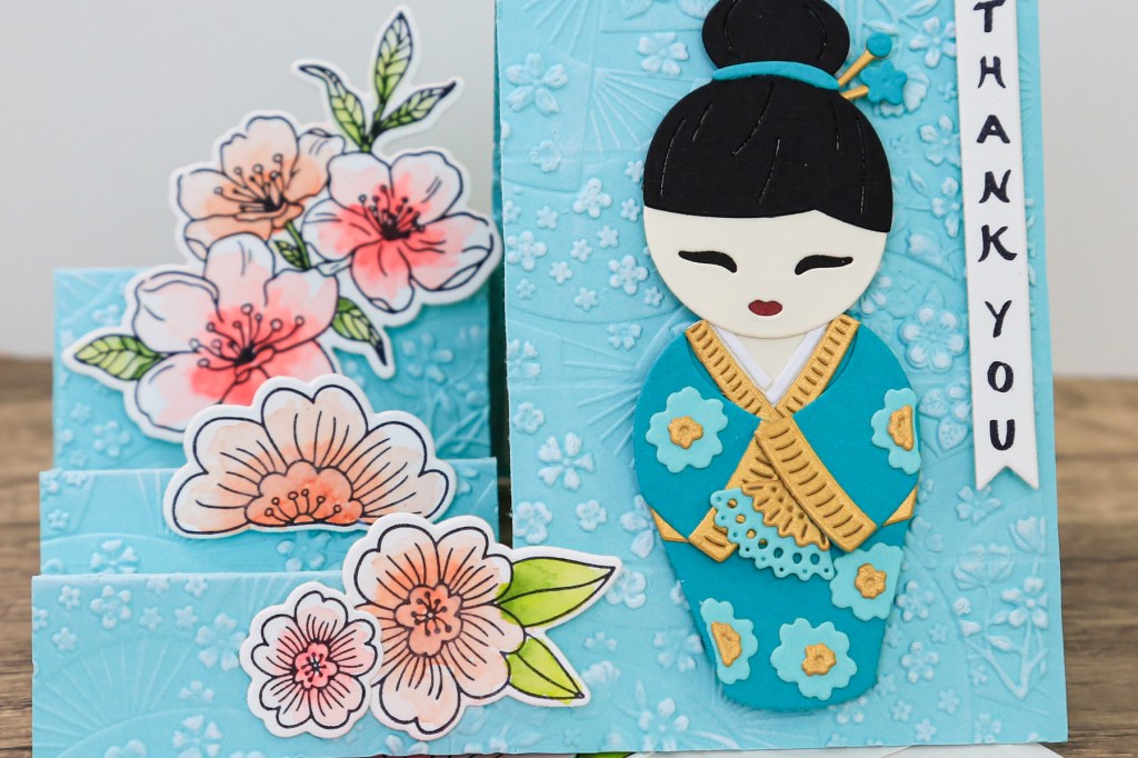 handmade card by Toni Chowdhury using the Spellbinders Spring in Kyoto collection featuring a Kokeshi doll, and cherry blossoms using bight spring colours