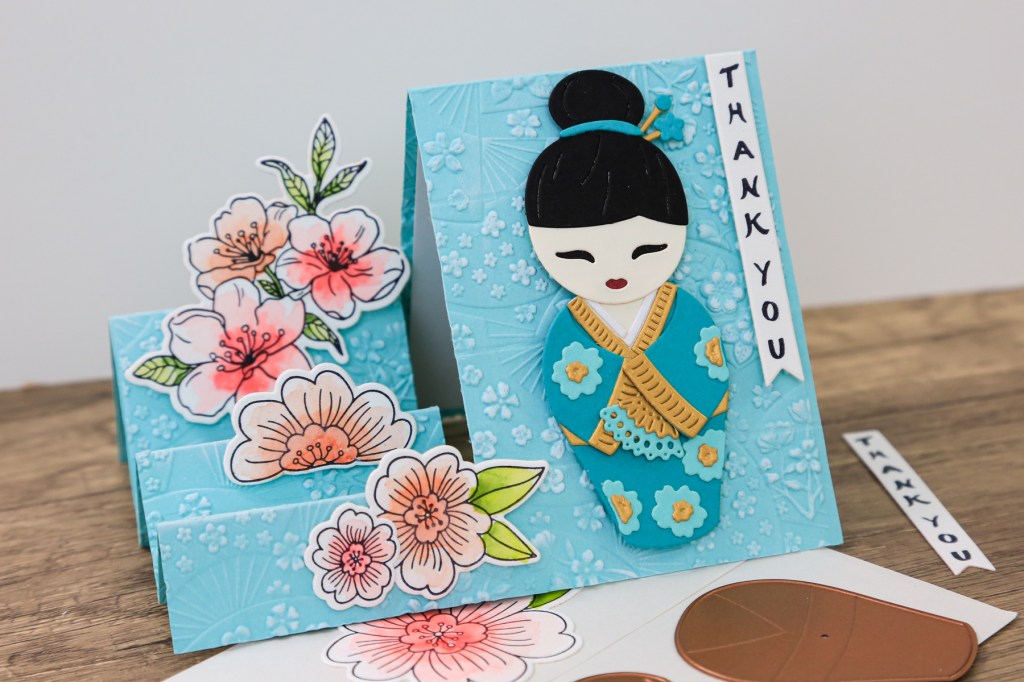 handmade card by Toni Chowdhury using the Spellbinders Spring in Kyoto collection featuring a Kokeshi doll, and cherry blossoms