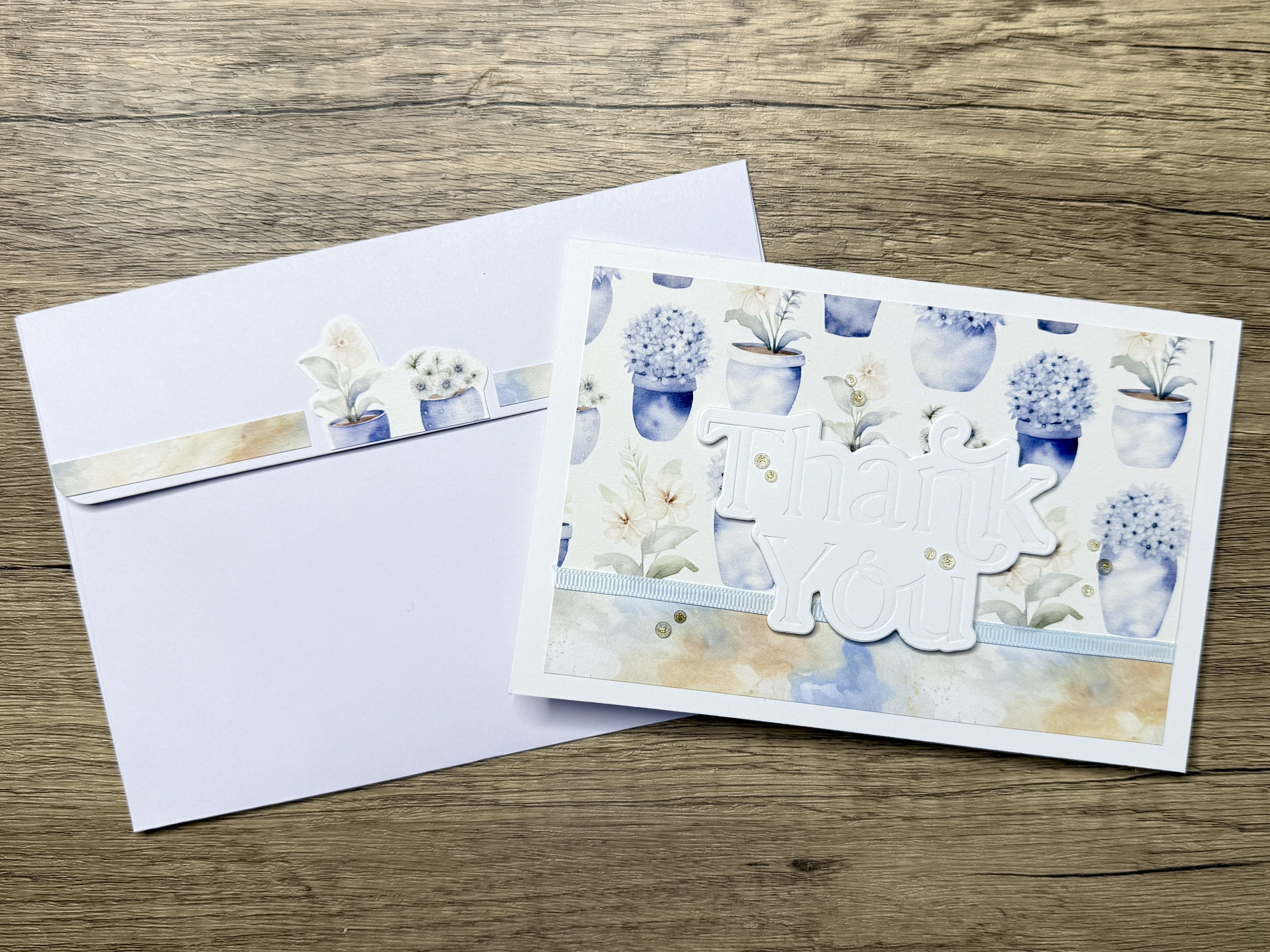 Handmade card featuring a floral design with an embossed 'Thank You' sentiment and a matching envelope with decorative elements.