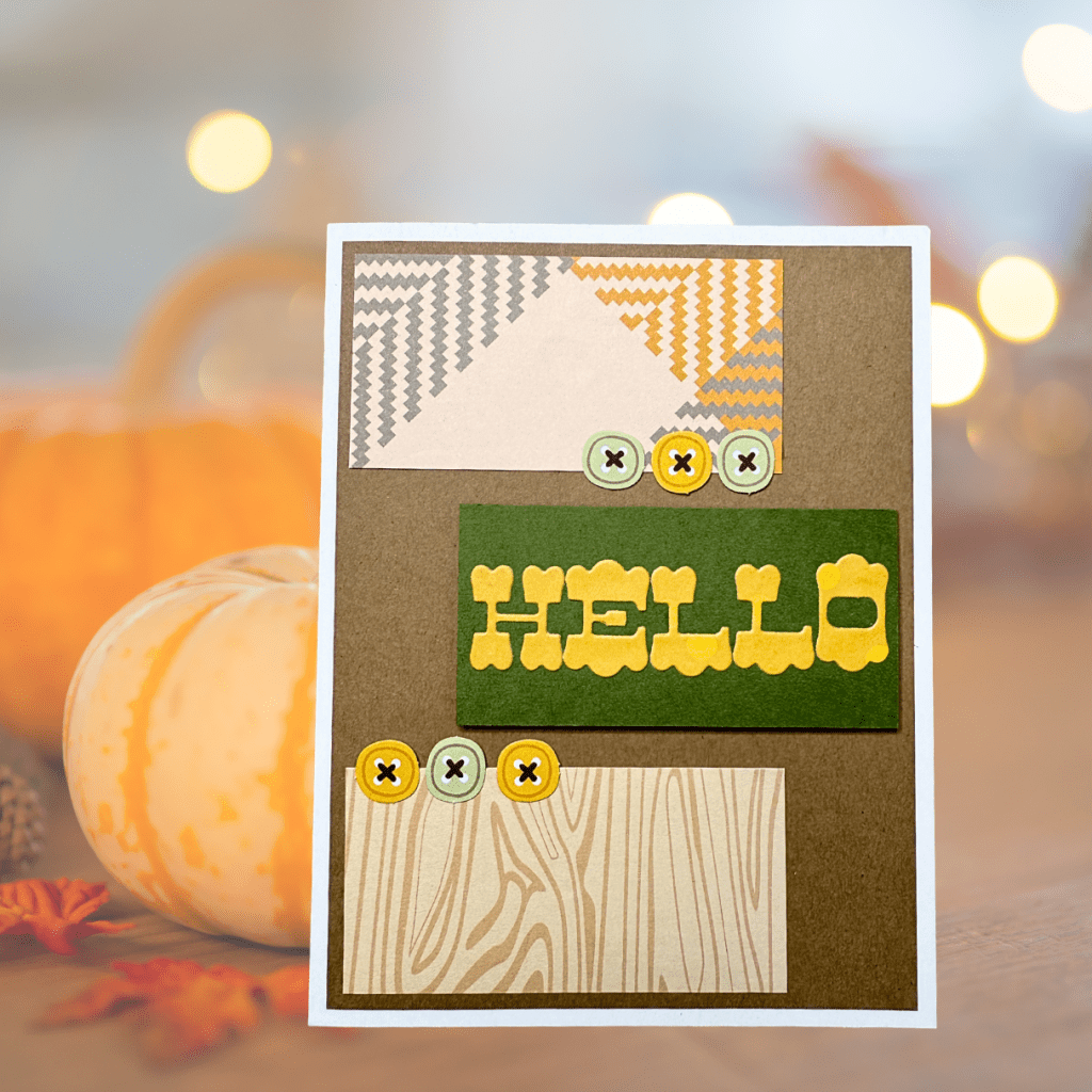 A handmade card featuring a 'HELLO' sentiment in yellow letters, surrounded by various patterned papers, buttons, and a wood grain design.