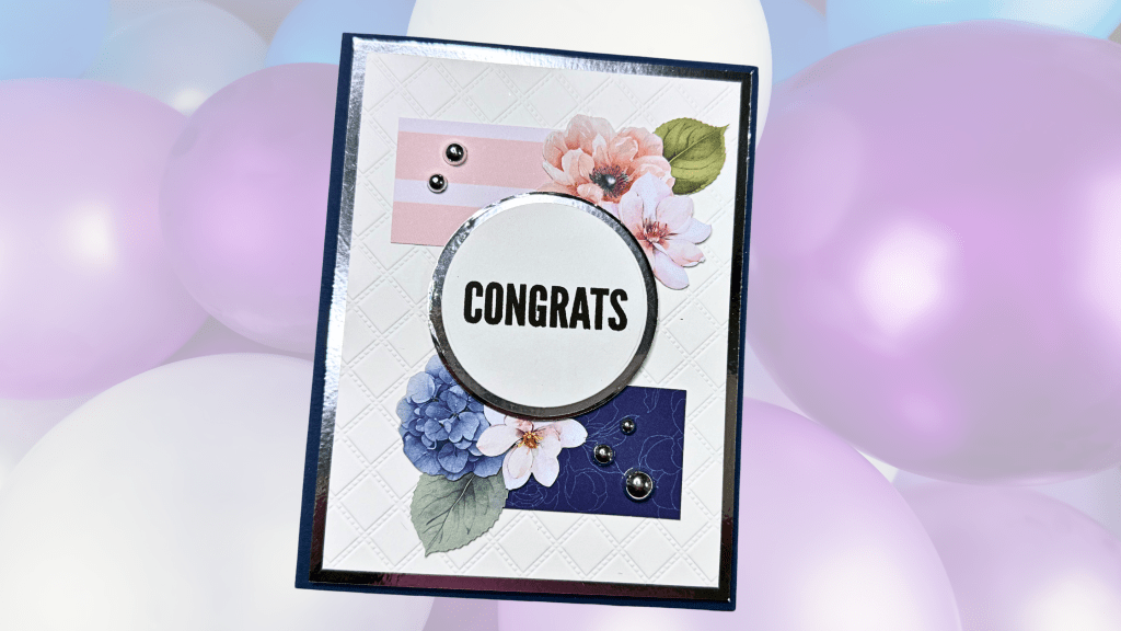 A handmade card featuring a floral design with the word 'CONGRATS' in bold letters, set against a background of pastel balloons.