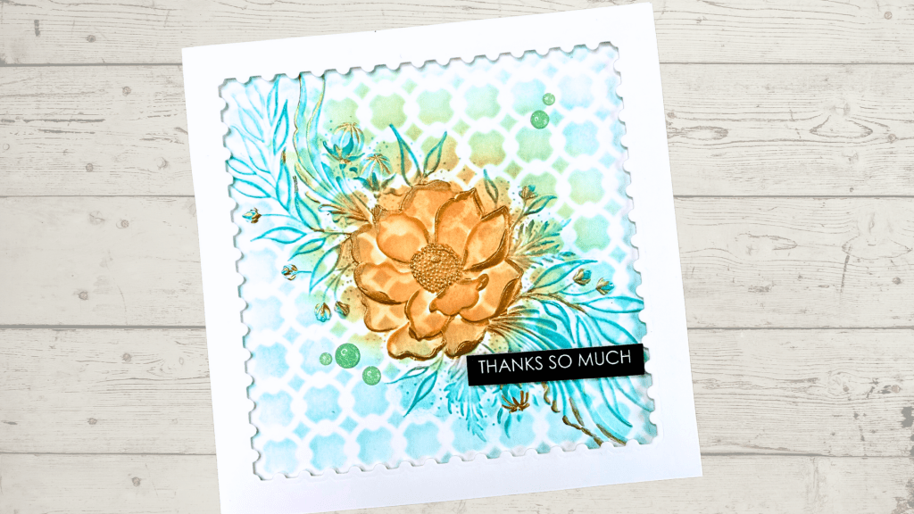 A handmade card featuring a large floral design in orange, surrounded by blue and green ink-blended accents, with the text 'THANKS SO MUCH' in black on a white background.