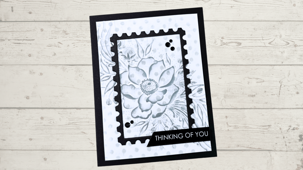 A handmade card featuring a floral design created with an embossing folder. The card is framed with a decorative edge and includes the sentiment 'THINKING OF YOU.'
