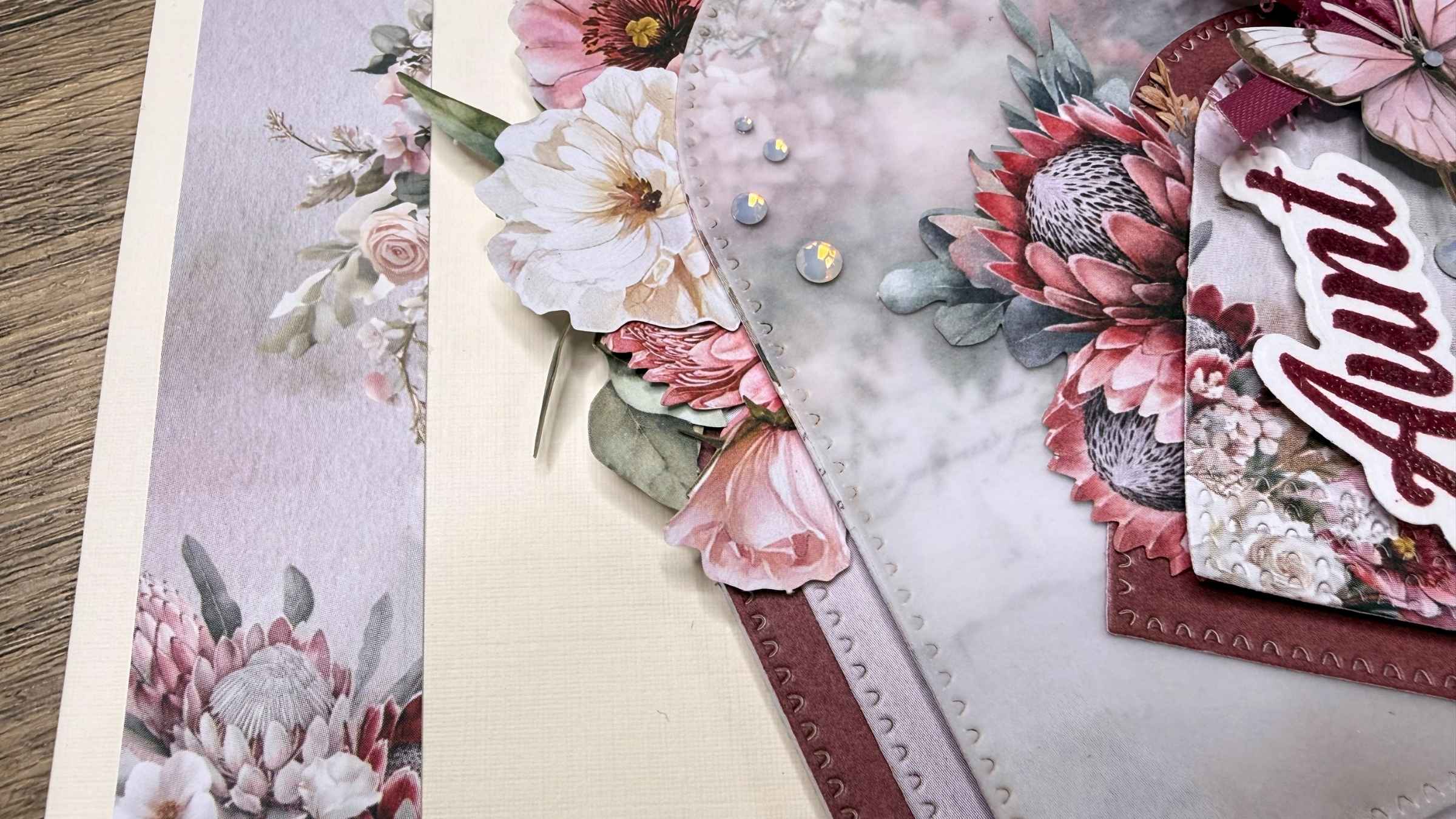 2 Layered floral-themed scrapbook paper with pink and white flowers and a butterfly embellishment