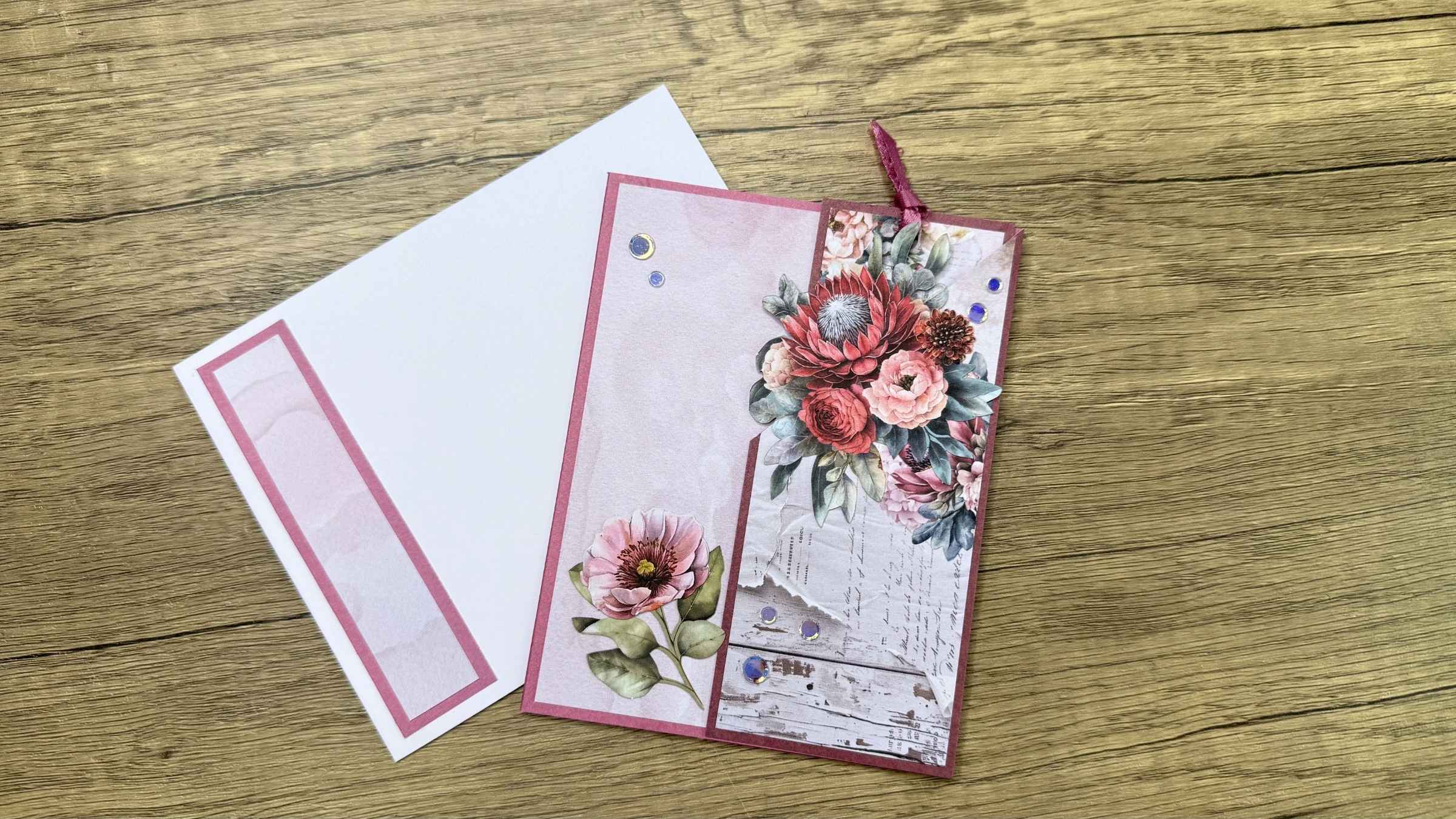 4 Decorative greeting card and envelope with floral design that includes a matching bookmark on wooden surface