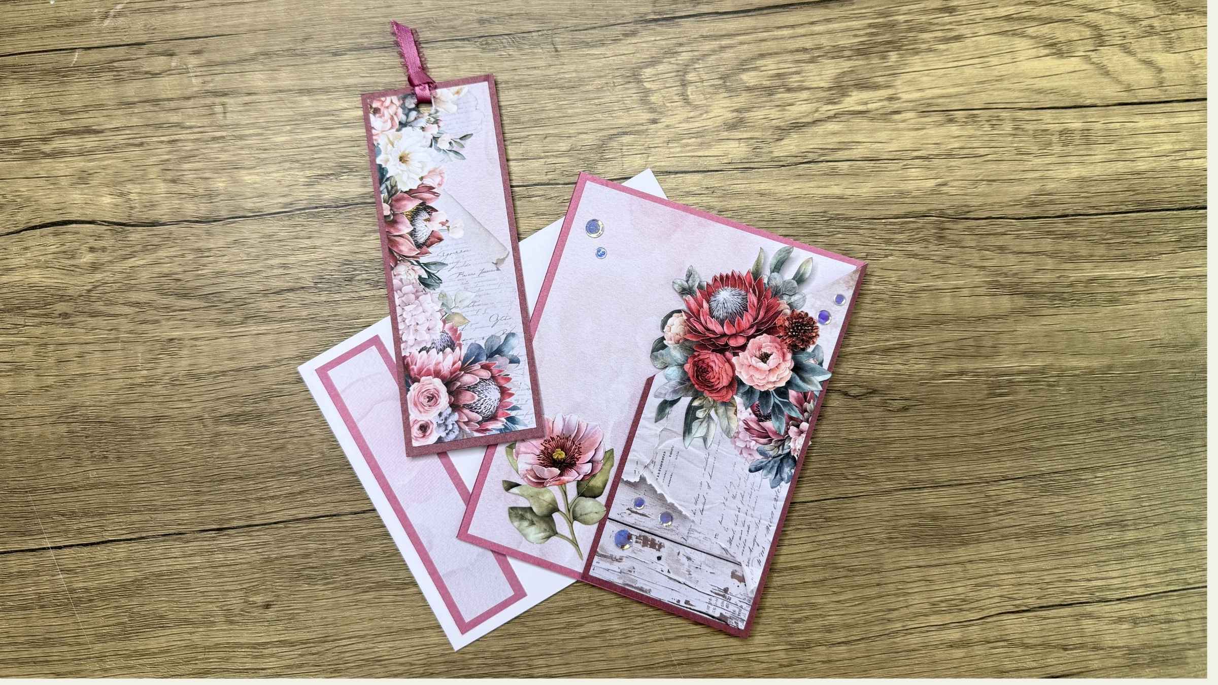 6 Decorative greeting card and envelope with floral design that includes a matching bookmark on wooden surface