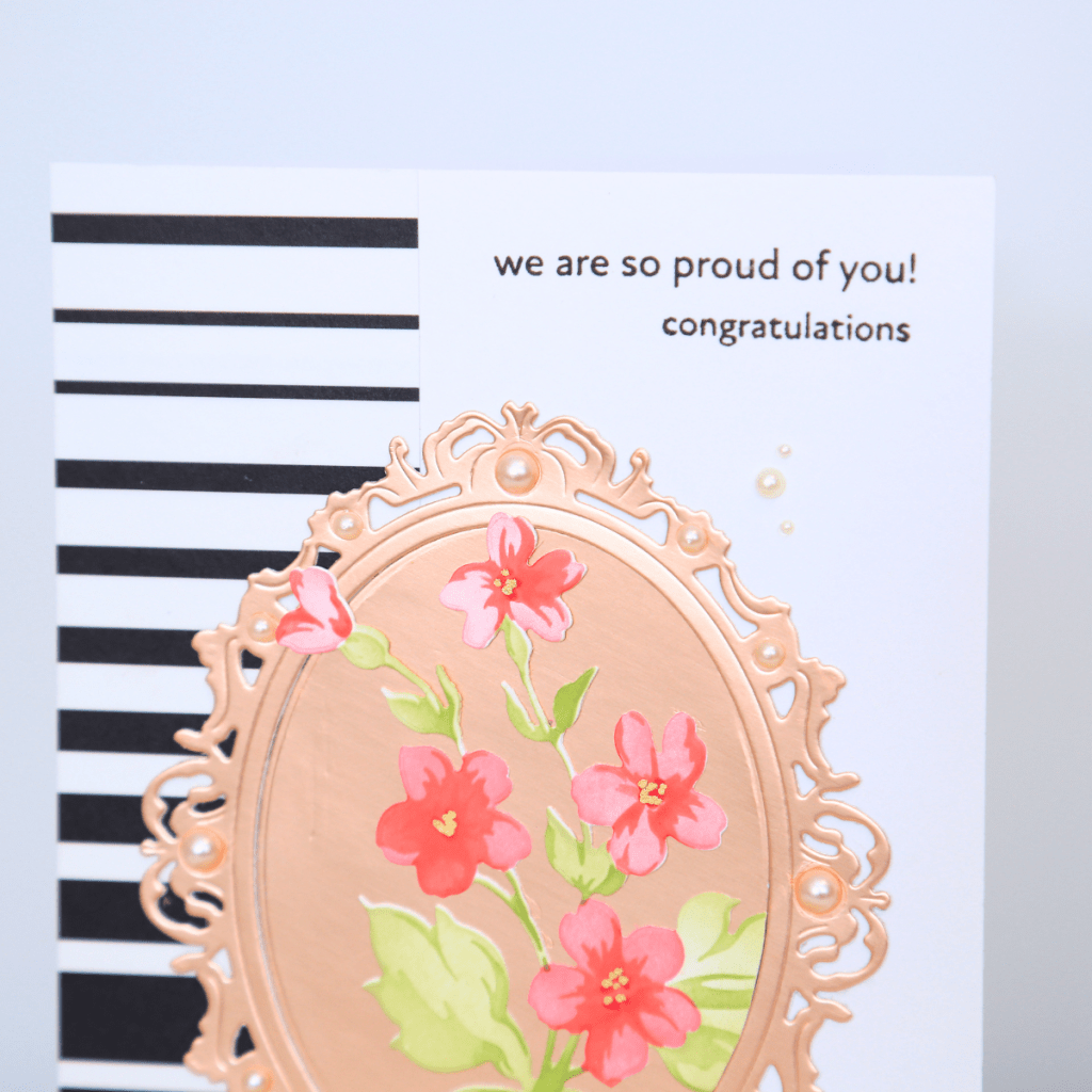 Card with black and white stripes, rose gold floral frame, and text reading 'we are so proud of you! congratulations'