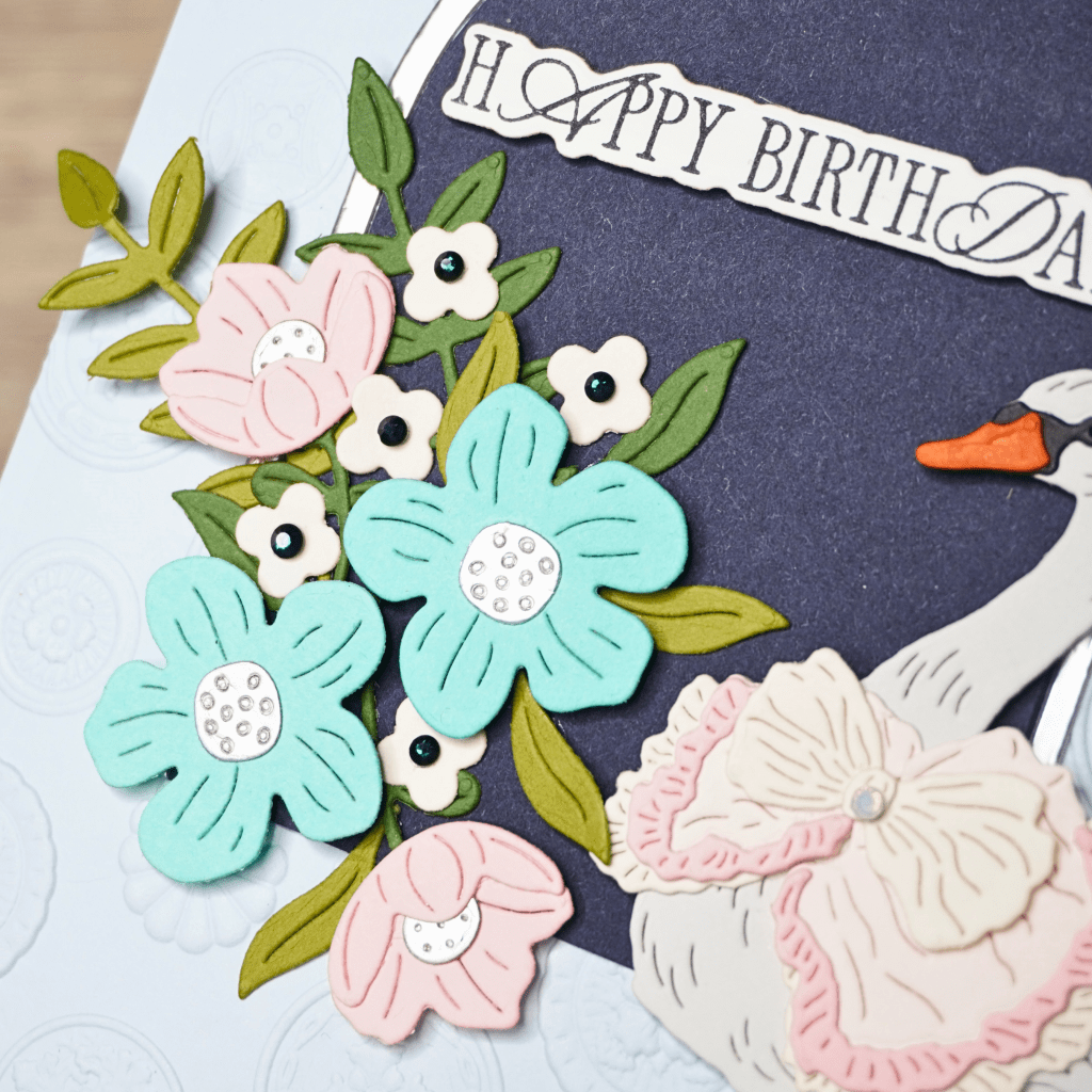 Elegant handmade birthday card featuring layered flowers and a dimensional swan.