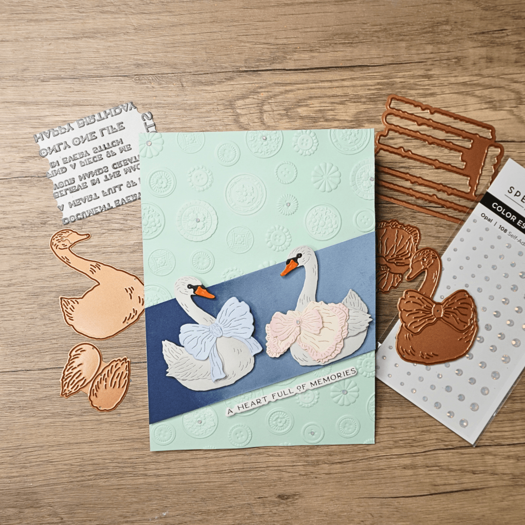 Romantic handmade anniversary card with two dimensional swans on an embossed floral background.